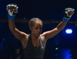 Bild av kvinna i MMA-handskar som gör en segergest med armarna